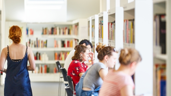 Eine Gruppe
                                          Studierender in der Bibliothek.