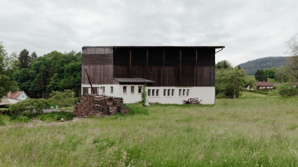 Bauernhof-Stall in gruener Landschaft