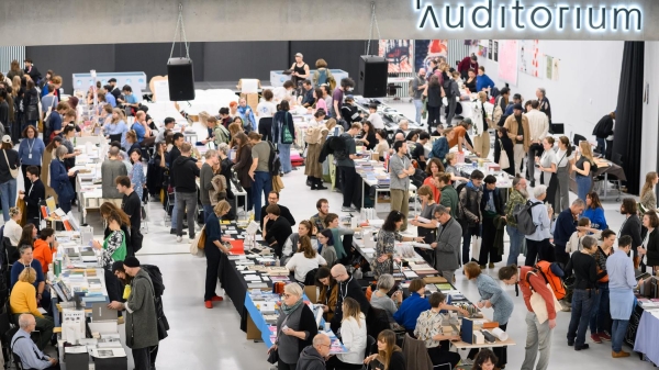 Atrium der Universität für Angewandte Kunst Wien während der Art Book Fair, gefüllt mit Menschen und Messeständen