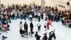 Foto der Begrüßung der
                                          neuen Studierenden: Fünf Redner*innen stehen im Atrium vor einer großen Gruppe Studierender.