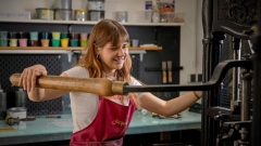 Janka
                                          Kocisek beim bedienen einer Druckerpresse auf der Universität für angewandte Kunst Wien