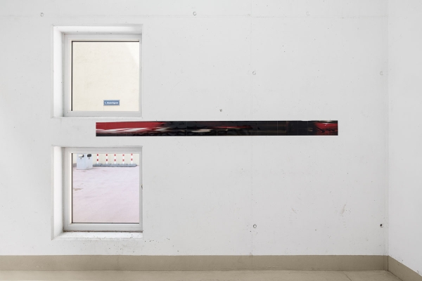 Ein weisser Raum mit zwei Fenstern und einem Streifen an der Wand