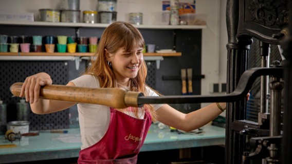 Janka Kocisek beim bedienen einer Druckerpresse auf der Universität für angewandte Kunst Wien